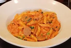 A bowl of pasta with meat and sauce.